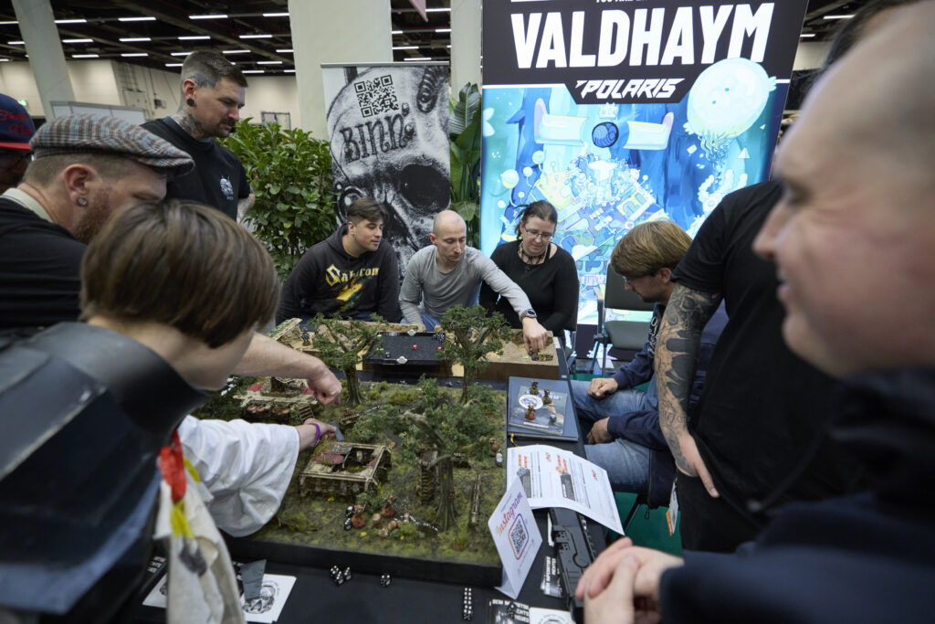 Foto von mehreren Gästen, die in der Tabletop Area gemeinsam ein Brettspiel spielen.