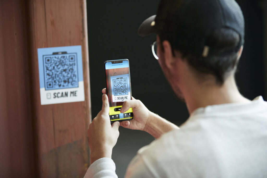 Bild von einer Person, die in der POLARIS App einen sammelbaren Sticker via QR-Code abscannt